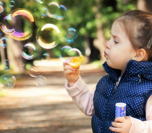 bambina con bolle di sapone