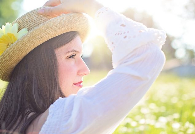 Donna con cappello contempla panorama