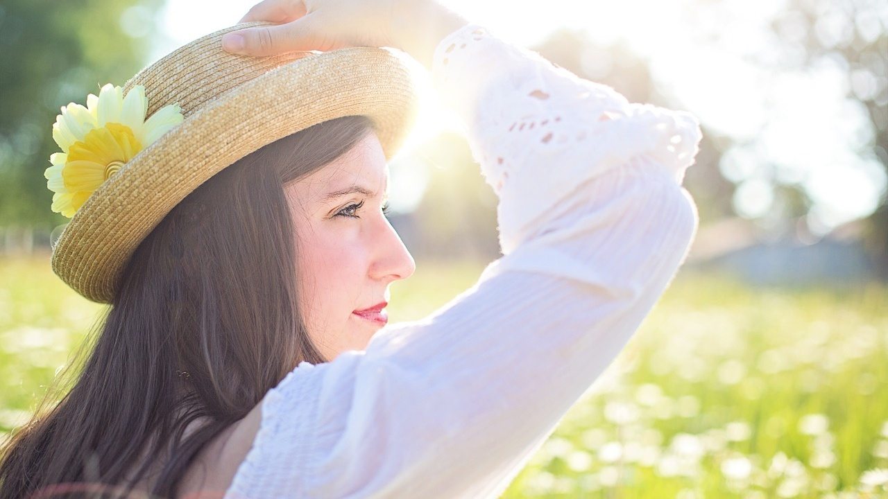 Donna con cappello contempla panorama